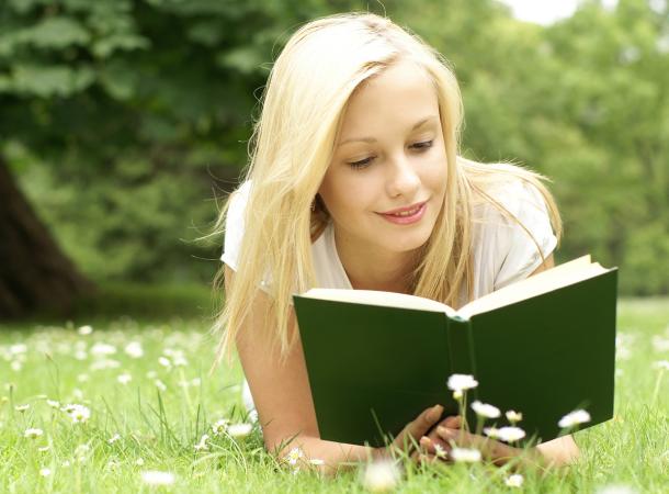 девушка читает книгу на природе